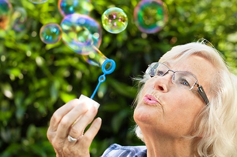 bigstock-Senior-woman-is-blowing-bubble-33764306